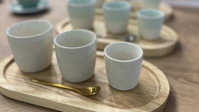 three white coffee cups on a wooden tray