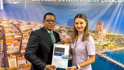 Curaçao Minister of Economic Development Ruisandro Cijntje holds copy of book labelled national export strategy