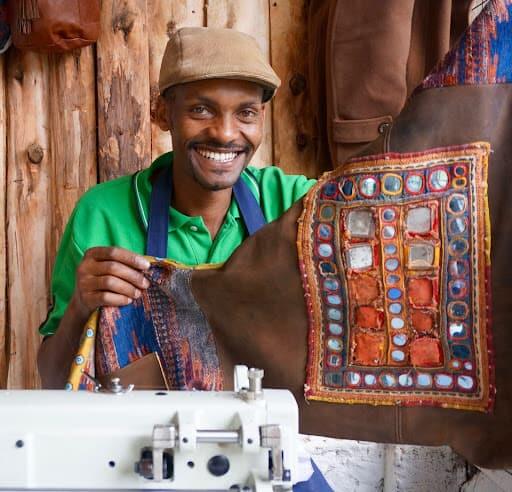 Tailor in Kenya showing sample cloth