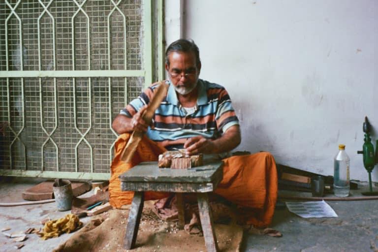 Man dying cloth by hand with wood blocks