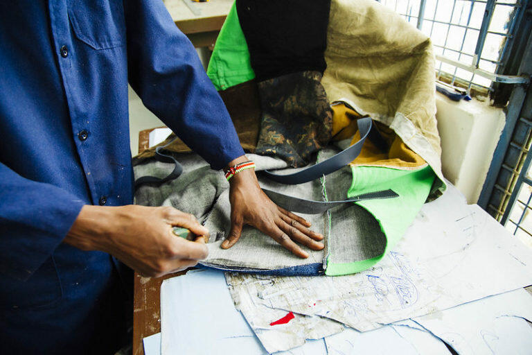 Kenyan tailor inspects fabrics