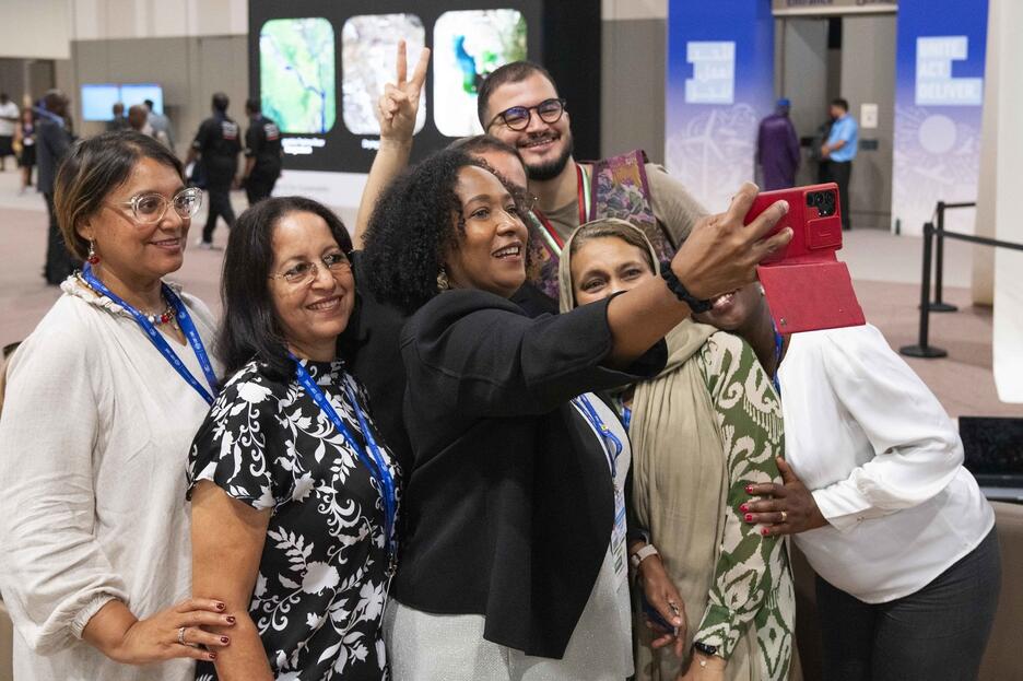 La directrice exécutive de l'ITC, au milieu de jeunes écopreneurs, prend un selfie du groupe avec son téléphone.