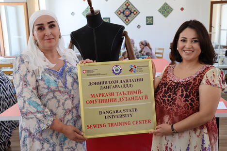 ITC’s Nargiza Abdumajidova (right) and Danghara Garment Training Centre’s official holding the entrance door tag, July 2022, Danghara
