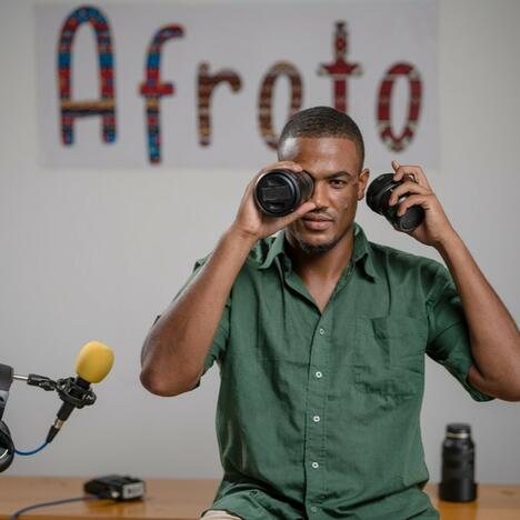 Senegalese man holds camera lens