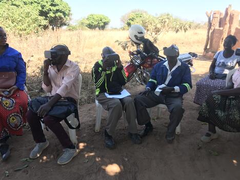Zambian farmers wearing virtual reality headsets