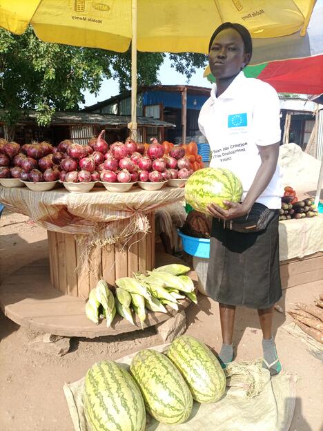 South Sudanese trader holds watermelon in market