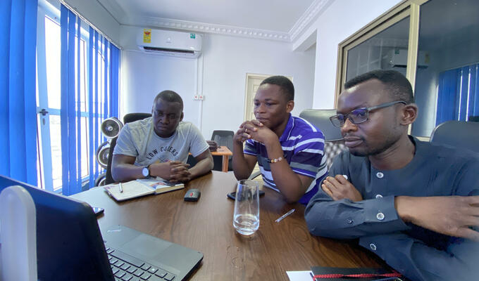 Three Ghanaian man around phone for conference call