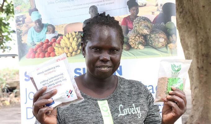South Sudanese farmer Helen Poni holds packet of seeds