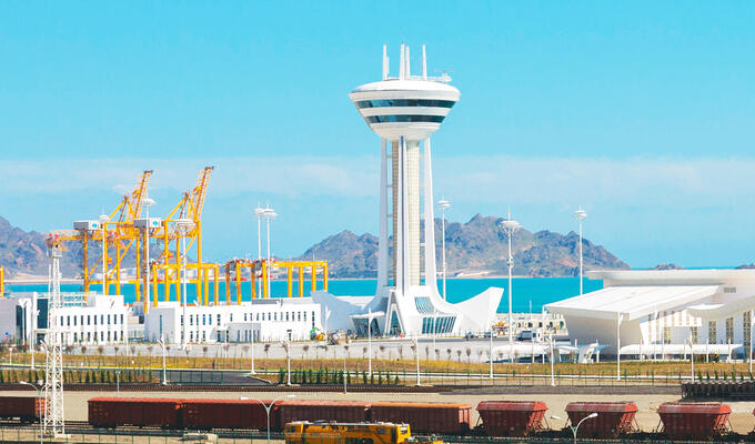A tower at the Turkmenistan sea port, with yellow cranes in background