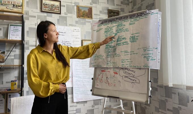 Ukranian woman stands next to flipchart at business development workshop