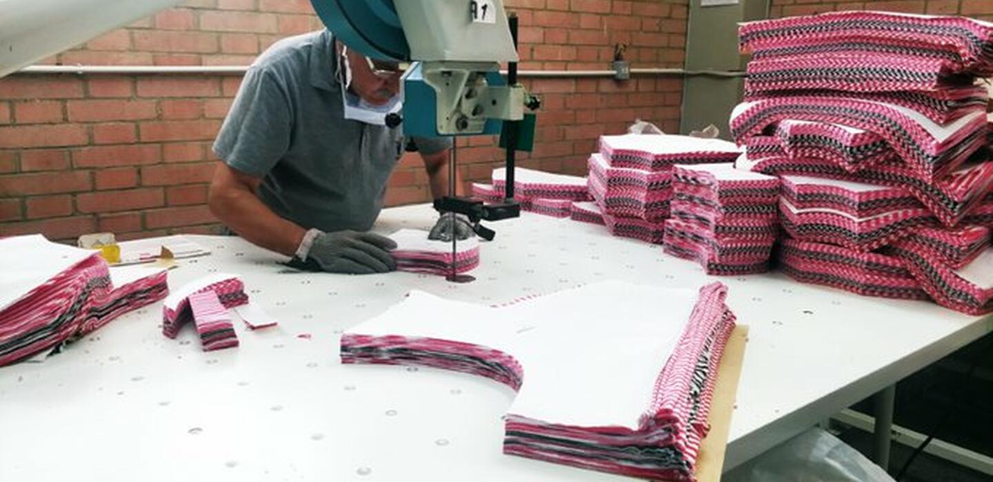Man cutting fabric pieces to produce clothes in an Egyptian company