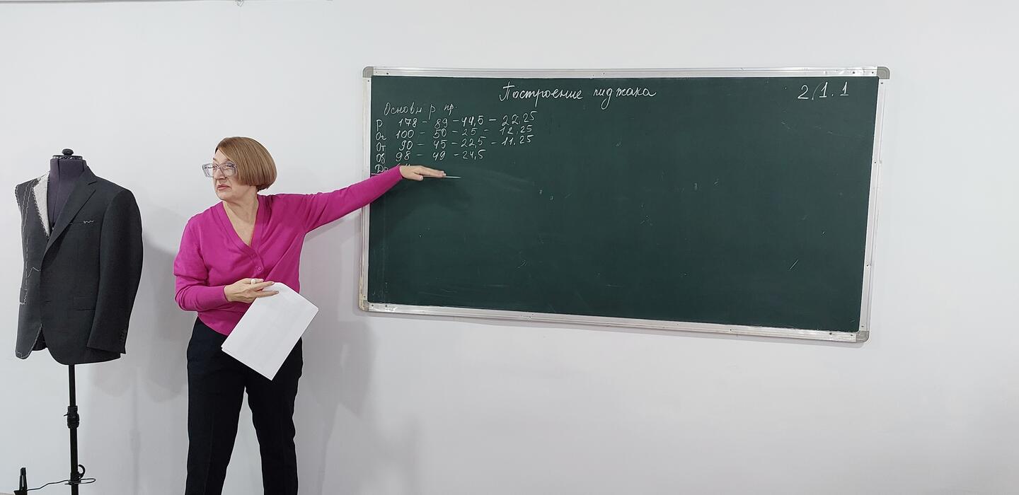 Woman points at board showing patternmaking skills