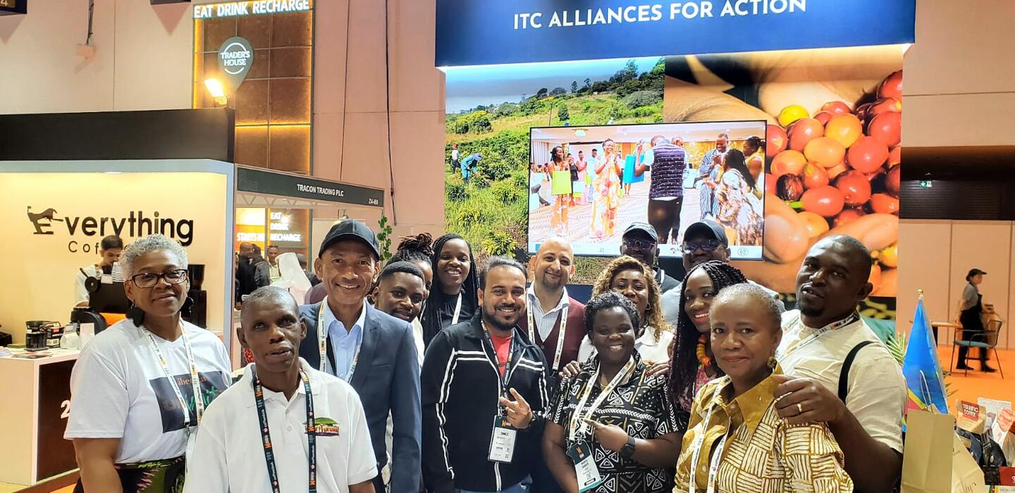 Un groupe de producteurs de café africains pose à l'intérieur d'un hall d'exposition.