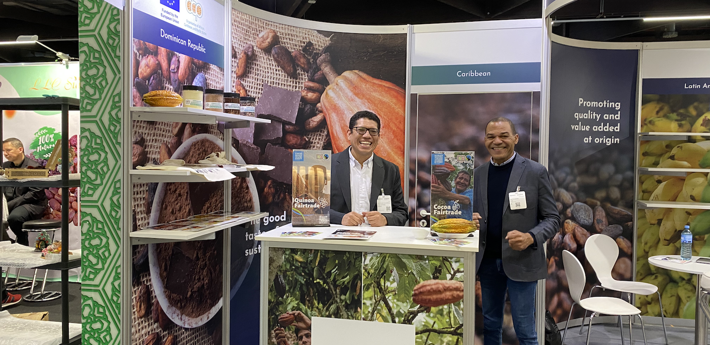 Two men stand at cocoa booth at organic trade fair
